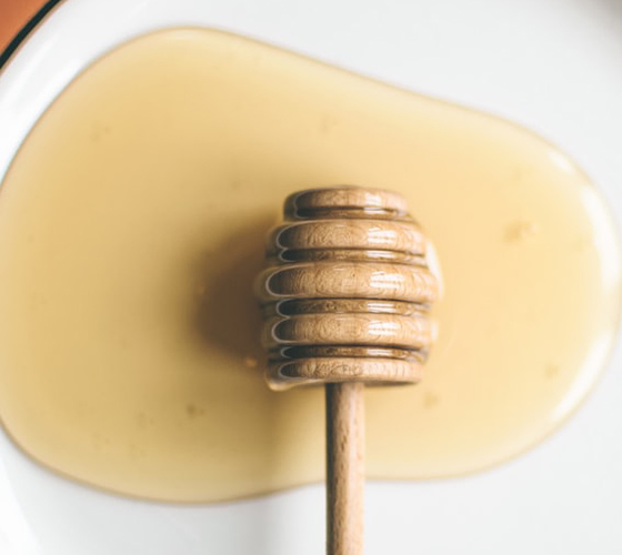 A honey dipper coated in honey