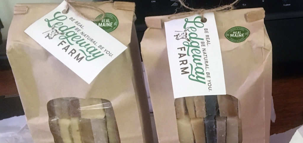 Brown bags of handcrafted soap with Real Maine branding on them