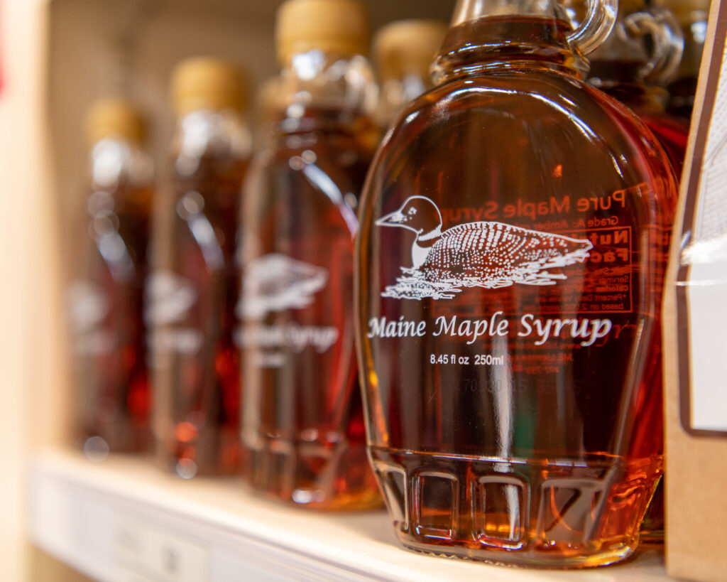 close up of Maine Maple Syrup in glass bottles on a shelf